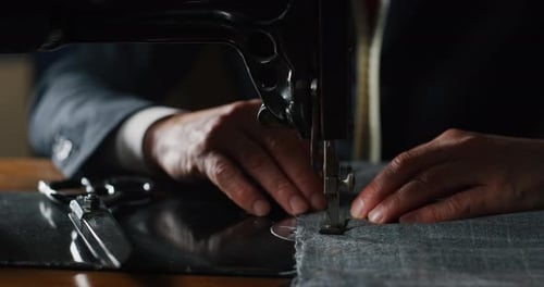 Filmmusik Makroaufnahme eines erfahrenen Schneiders, der in Ancie maßgeschneiderte, handgefertigte, hochwertige Kleidung näht