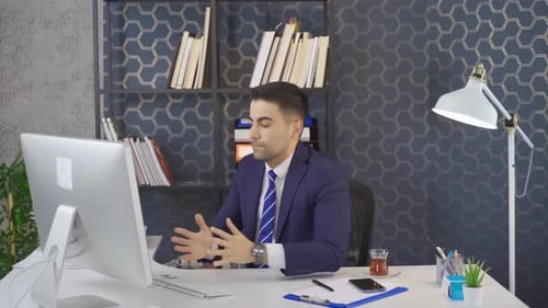 Office worker businessman works at computer and is angry.