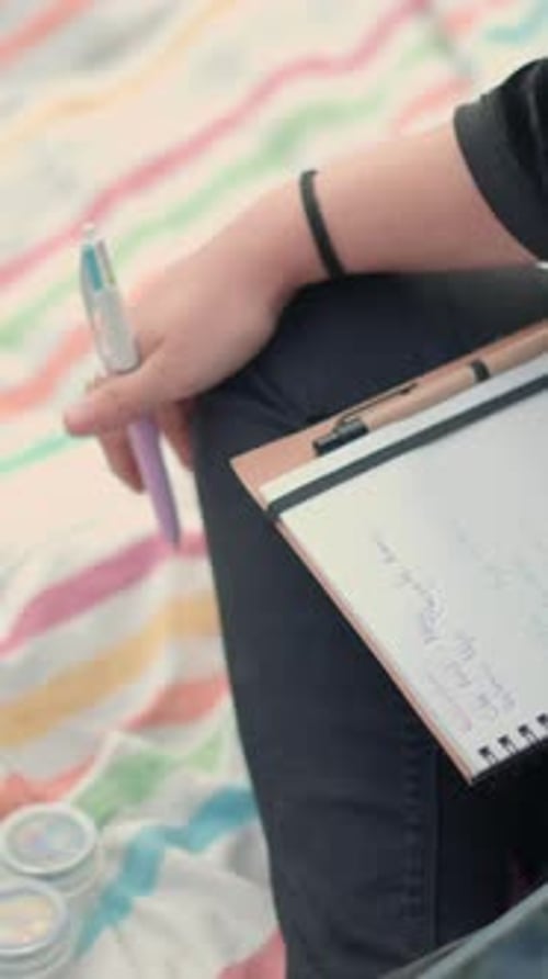 Close Up on Human Hands Holding a Notebook and a Smartphone High Angle View