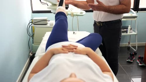 Doctor checking the leg mobility of a patient on the stretcher