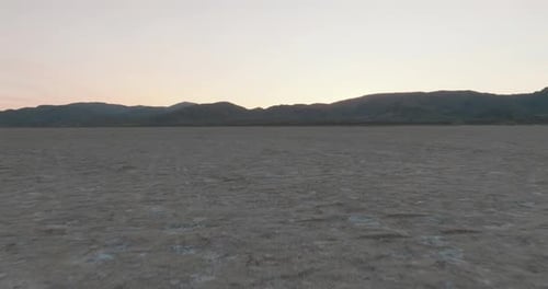 a large flat area with mountains in the background
