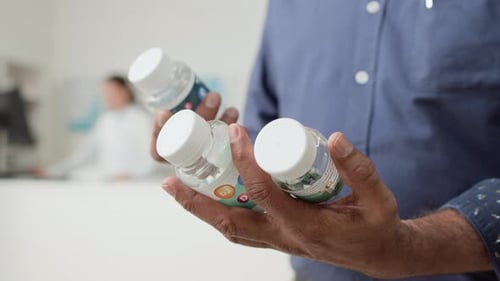 Unrecognizable Man Reading Labels in Pharmacy