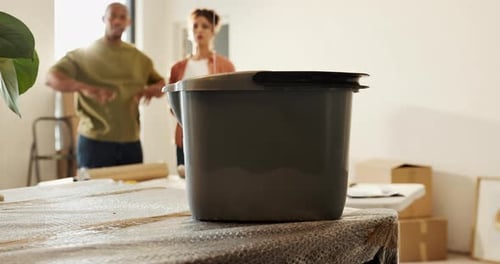 Leak, bucket and couple in new home with stress for repair, maintenance or assistance with moving