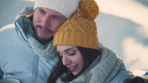 Winter Time Young Couple Rests in a Winter Forest and Communicate a Man and a Young Woman Sit on a