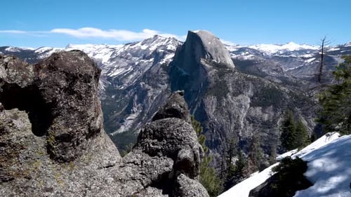 Half Dome peak in Yosemite National Park California seen from rocky cliff, Aerial dolly in shot
