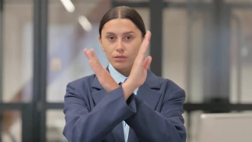 Professional Woman Shakes Head and Crosses Arms Saying No