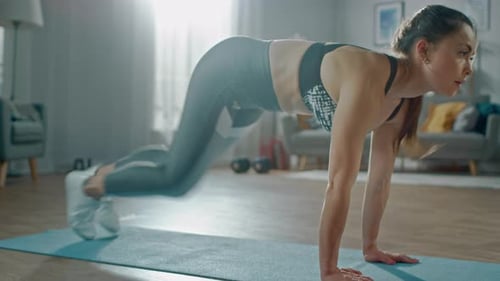 Athletic woman doing mountain climber exercise on mat