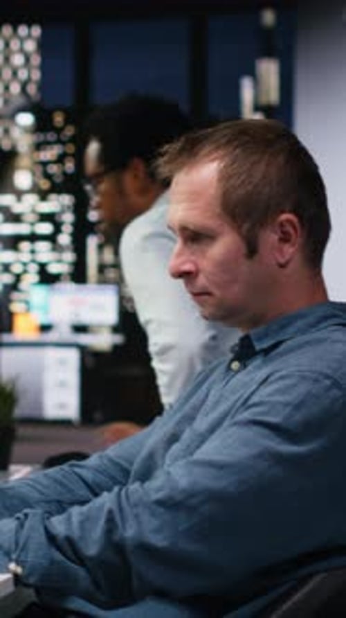 Vertikaler Videoadministrator im Büro wartet darauf, dass der Code fertig kompiliert ist