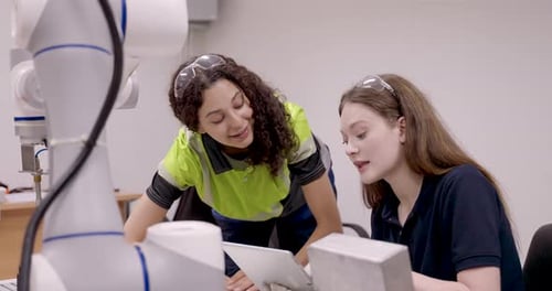 une stagiaire vérifie l'alignement robotique lors d'une session d'assemblage automatique avec une instructrice