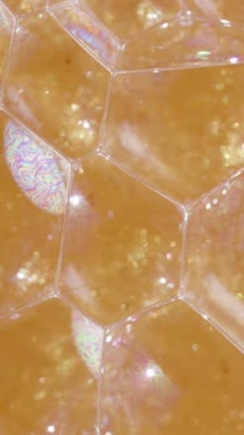 Abstract Amber Bubbles Reflect Iridescent Light Up-Close