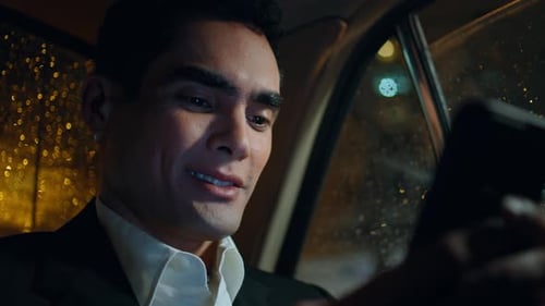 Man in Taxi Looking at Phone at Night