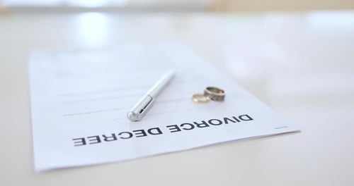 Divorce papers, rings and pen for agreement, family law and breakup for relationship issues