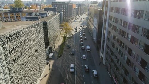 Aerial Drone Footage Flying Above a City Urban Street with Moderate Car Traffic. Sunny Day on a Str