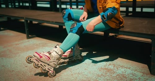 Teenager Roller Skater Girl with Blue Hair Puts on Roller Blades Protection at Skate Park Training