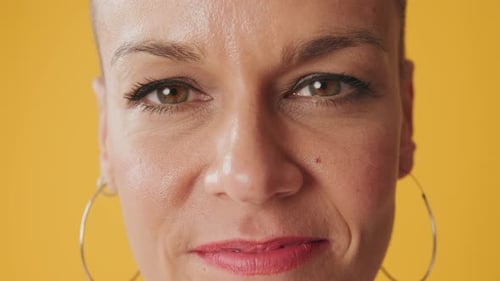 Detailed close-up shot of woman's face isolated on yellow background