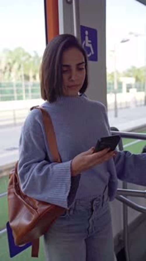 Young Woman Using Cellphone on Public Transportation