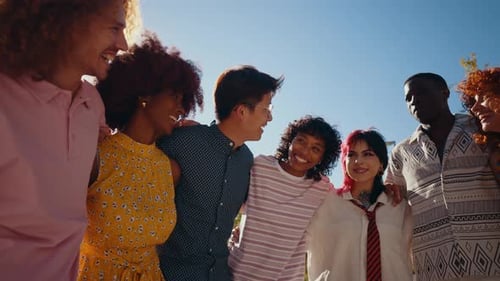 Happy playful multiethnic group of young friends bonding outdoors.