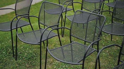 A Set of Charming Outdoor Metal Chairs Resting on the Lush Green Grass Surface Outdoors