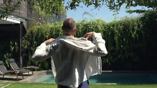 Man Putting on Shirt in Garden, Super 240
