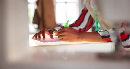 Designer Drawing on a Notepad With a Pen