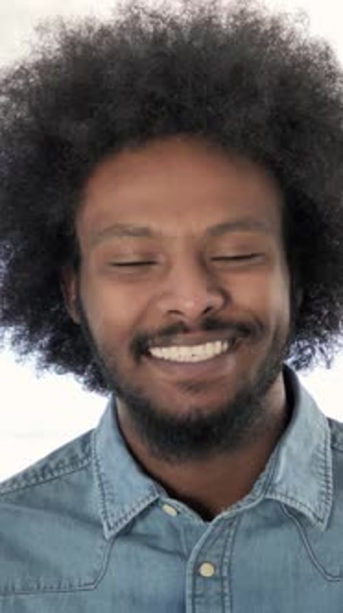 Smiling Man with Afro and Denim Shirt Close Up