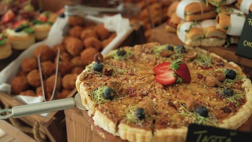 Nahaufnahme einer Reise, die eine Käsetarte mit frischen Erdbeeren und einen Korb voller Wi zeigt