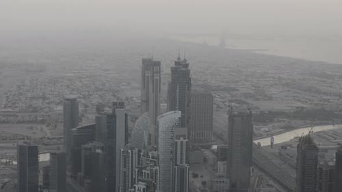An aerial shot of downtown Dubai skyscrapers with the Persian Gulf in the distance. Filmed in the ev