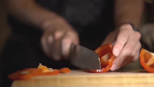 Chef Cutting And Slicing Red Capsicum Into Julienne's Cut Using A Sharp Knife. - close up