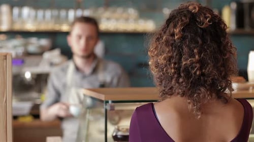Woman Receives Coffee From Barista At Cafe