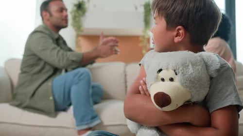 Sad Boy Hugging Teddy Bear During Parental Argument