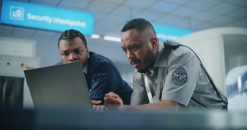 Airport Security Checkpoint Security Officers Using Laptop Computer and Talking
