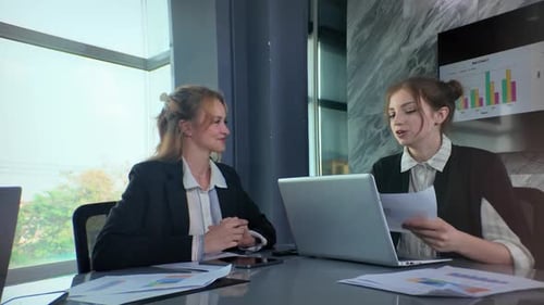 Business meeting in modern office between two professionals discussing documents