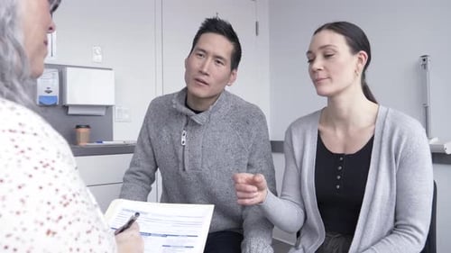 Couple Discusses Medical Information with Doctor in Office