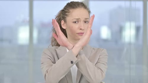 Portrait of Young Businesswoman saying No by Hand Gesture