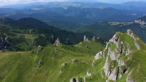 Flying Above Vibrant Green Rocky Mountains and Cliffs, Aerial View
