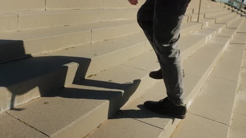 Person Climbing Urban Concrete Staircase During Daytime