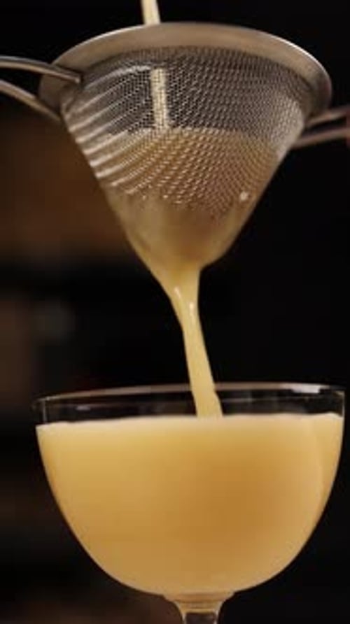 A bartender prepares an alcoholic cocktail . Close-ups