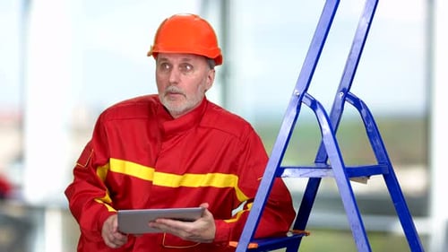 Construction Worker in Red Uniform Holding Tablet Pc