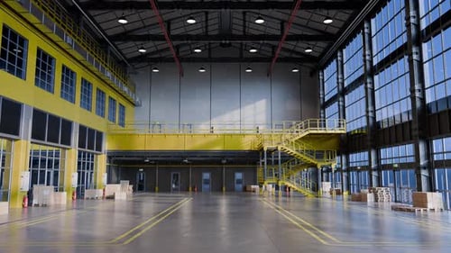 Interior de almacén vacío con luz solar que entra por las ventanas