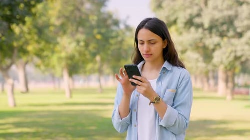 Woman Using Smartphone in Urban Park Setting