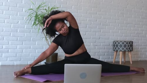 Woman Practicing Yoga at Home On Her Mat