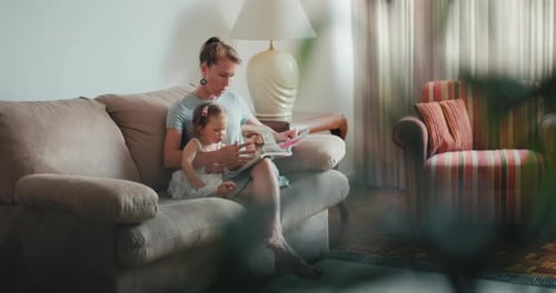 Mother Reading a Book to her Little Daughter