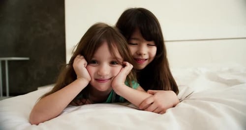 Two Happy Small Kids in Bedroom Smiling and Looking to the Camera