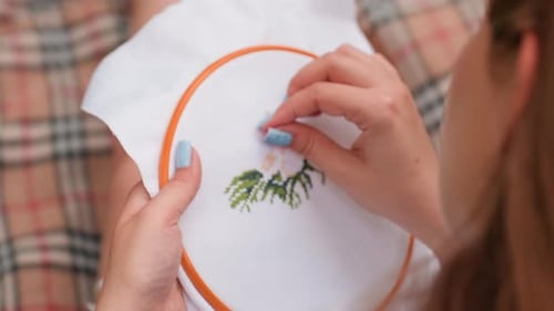 Close Up Rear View Of Student Embroidering Tree Design On Fabric Outdoors