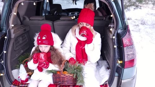 Family - mother and daughter cheerfully celebrate Christmas in the forest