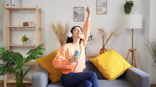 Woman Listening to Music and Dancing on Couch