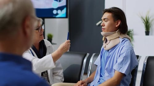 Doctor Consults with Young Adult Patient in Clinic
