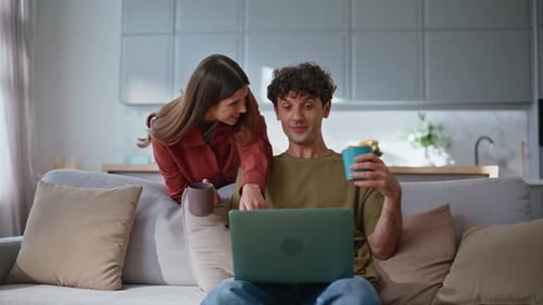 Woman and Man Using Laptop Together in Living Room