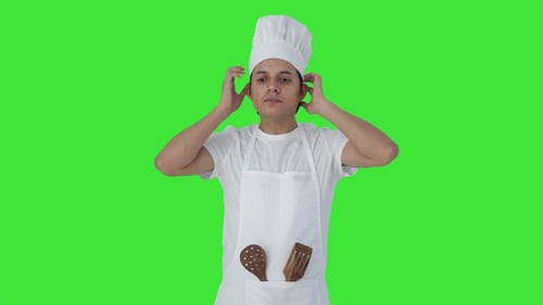 Serious Indian professional chef getting ready Green screen