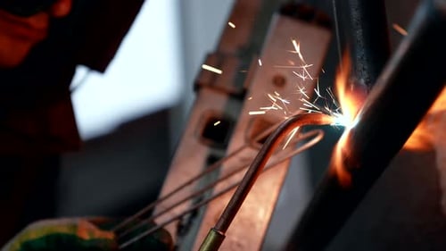 Nahaufnahme des Schweißens von Metallrohren in einer Industriewerkstatt Professioneller Schweißer mit Schweißgerät